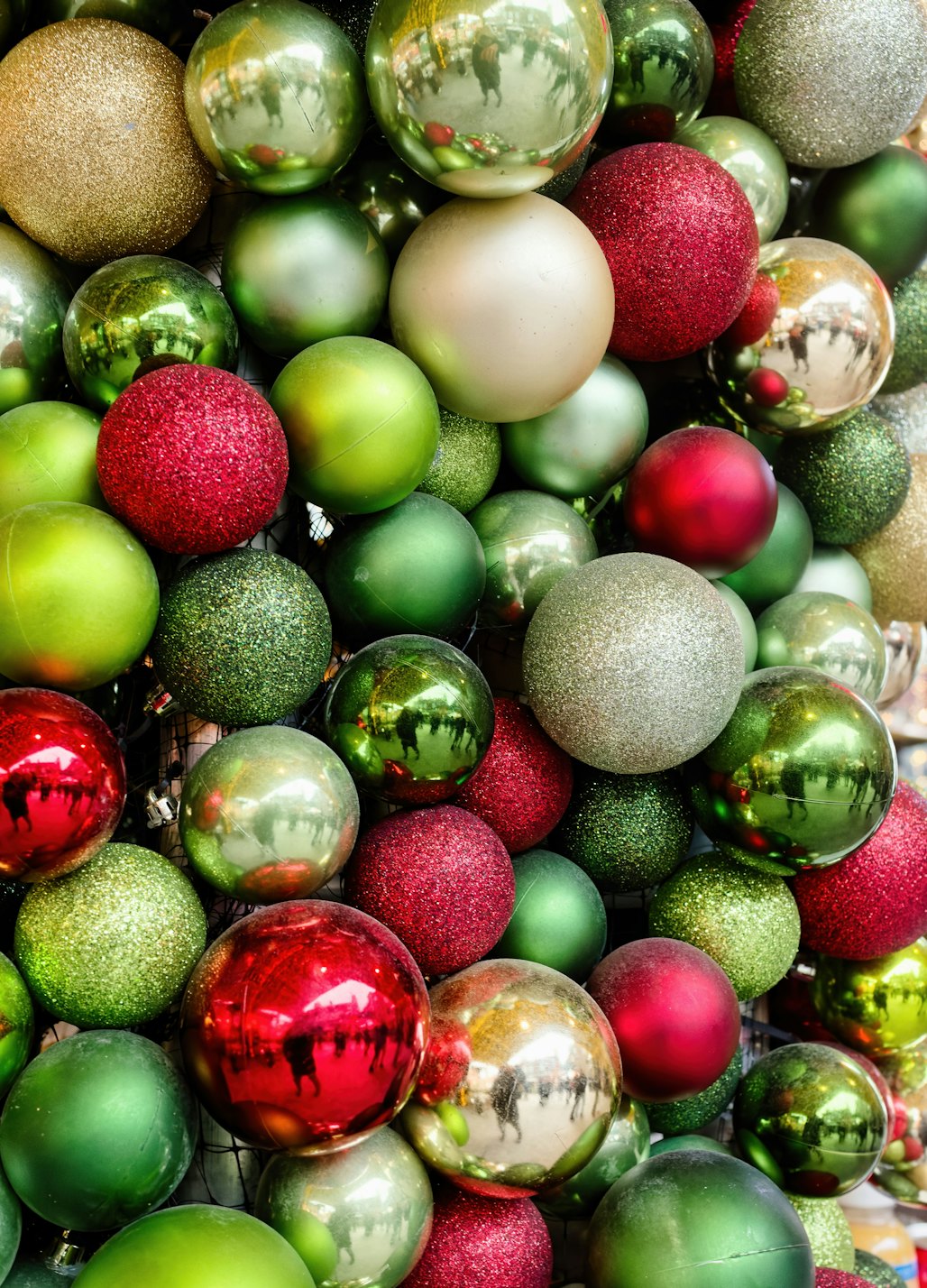 A heap of glass ornaments in red, green, gold and silver