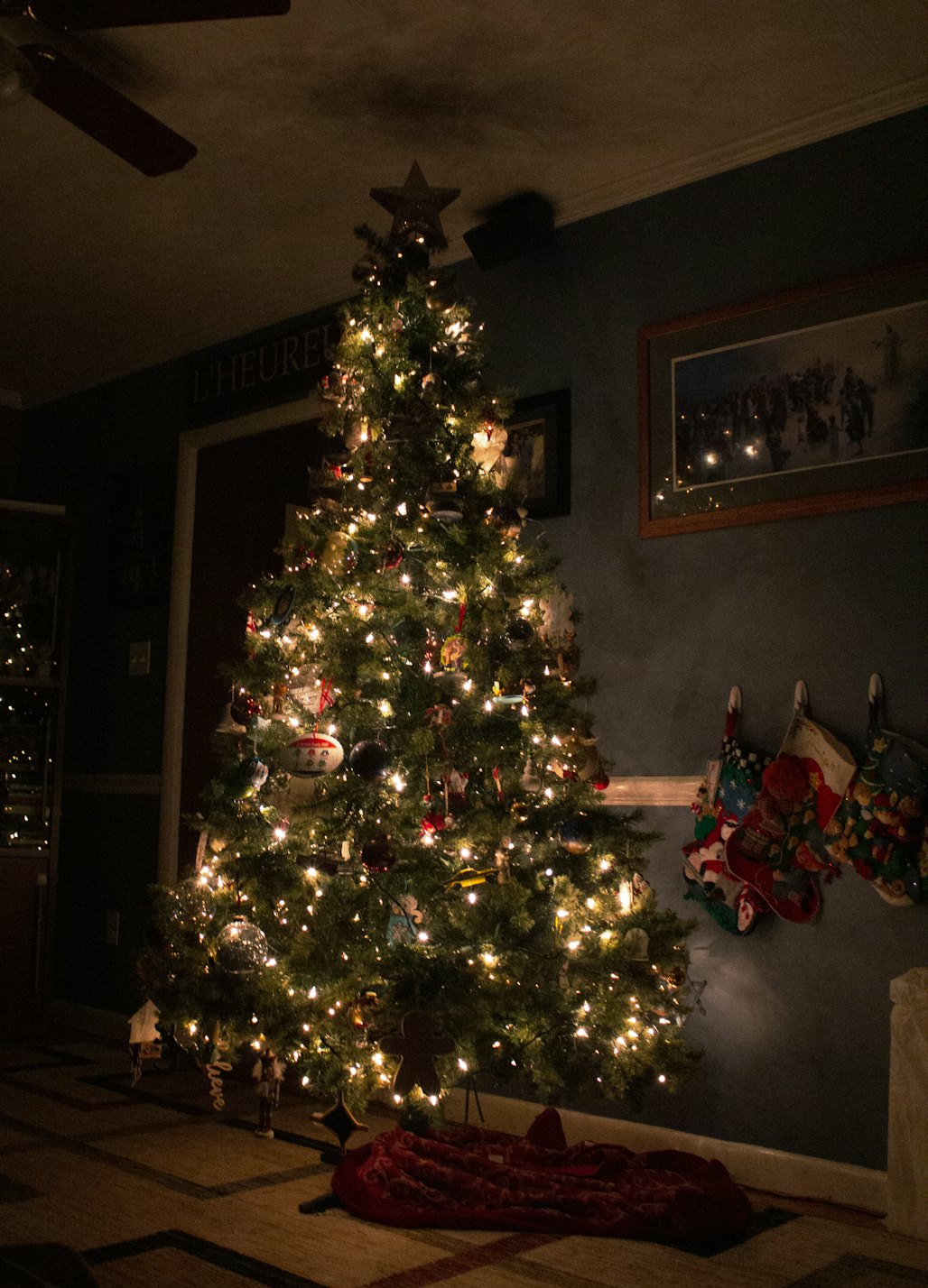 Fully trimmed Christmas tree glowing with warm white lights in a dark room